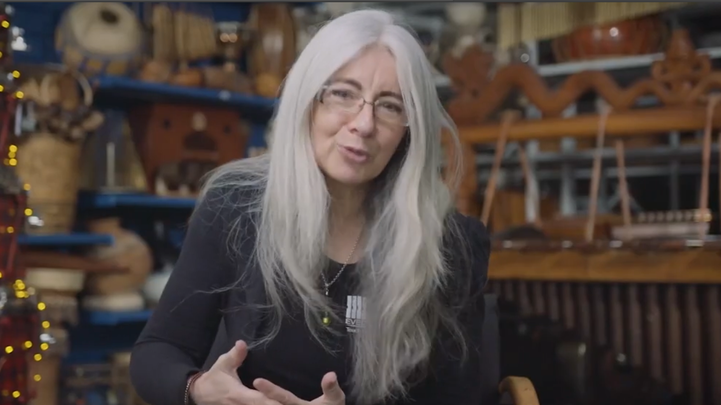 Dame Evelyn Glennie sitting amongst her collection of percussion instruments