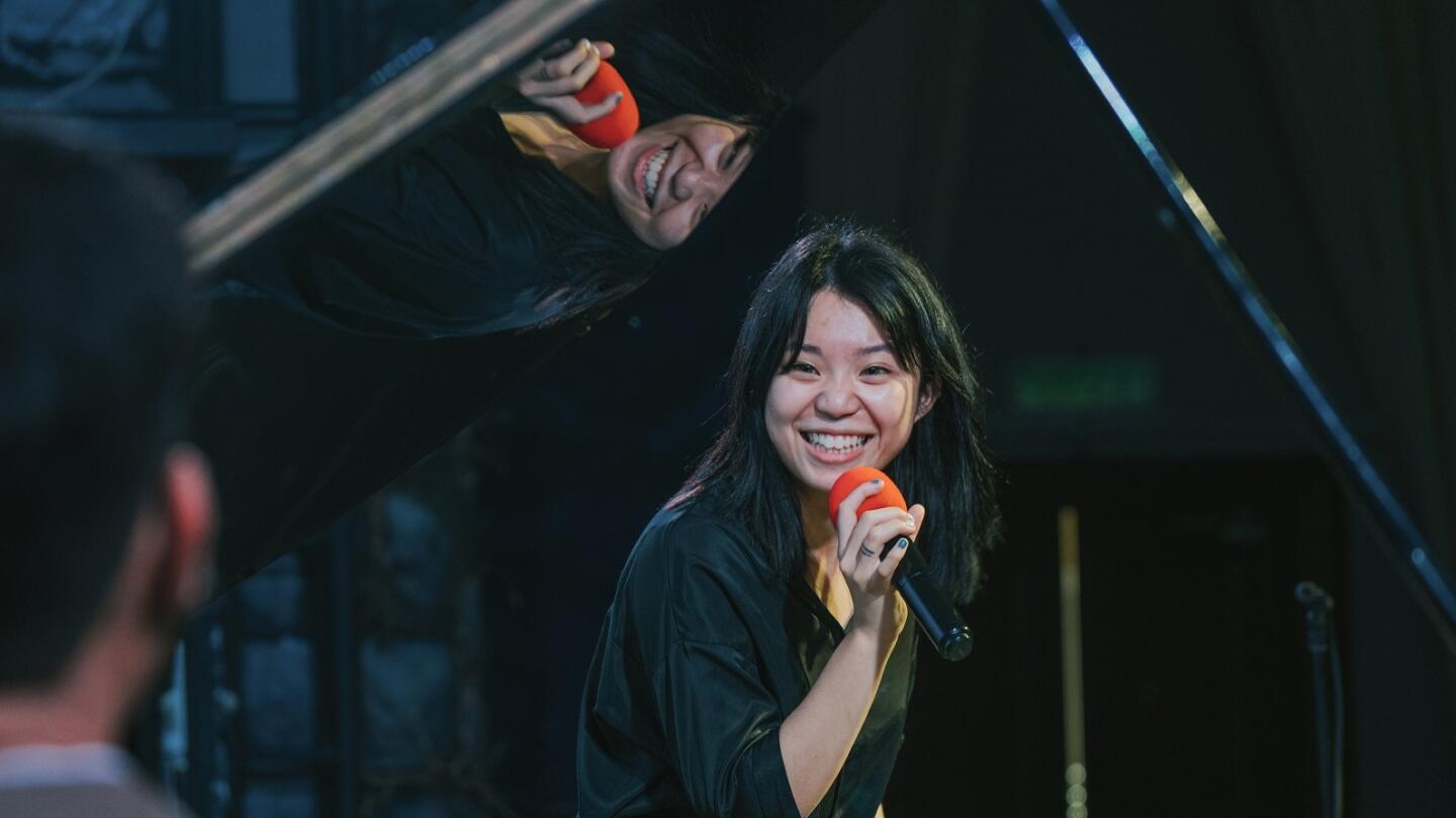 Young female opera singer enjoy practising solo on stage with pianist