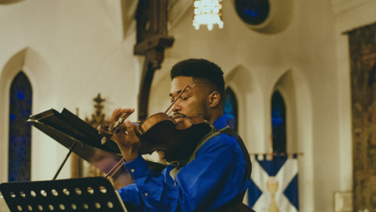 A musician playing a violin in a church