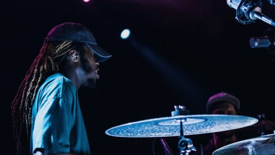 Drummer playing a drum kit onstage